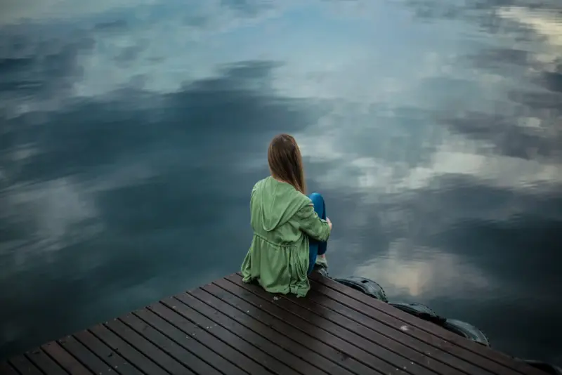 Young woman sitting at the lake