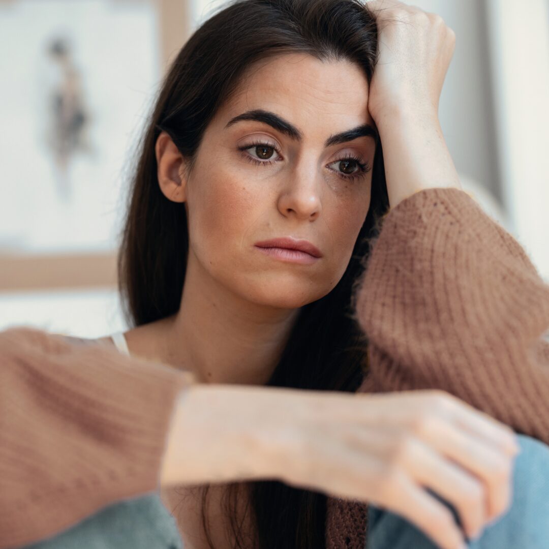 pensive woman resting her head on hand